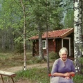 Ingeborg (sonhustru) vid sin gäststugan.